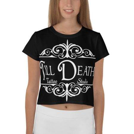 A person wearing a crop tee featuring an all-over print design with "Till Death Tattoo Studio" beautifully showcased in white decorative font.