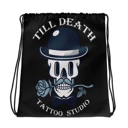 The all-over-print drawstring bag showcases a skull adorned in a bowler hat, gripping a rose between its teeth. Featuring bold text that reads "Till Death Tattoo Studio," it's the ideal accessory for those with an edgy style.